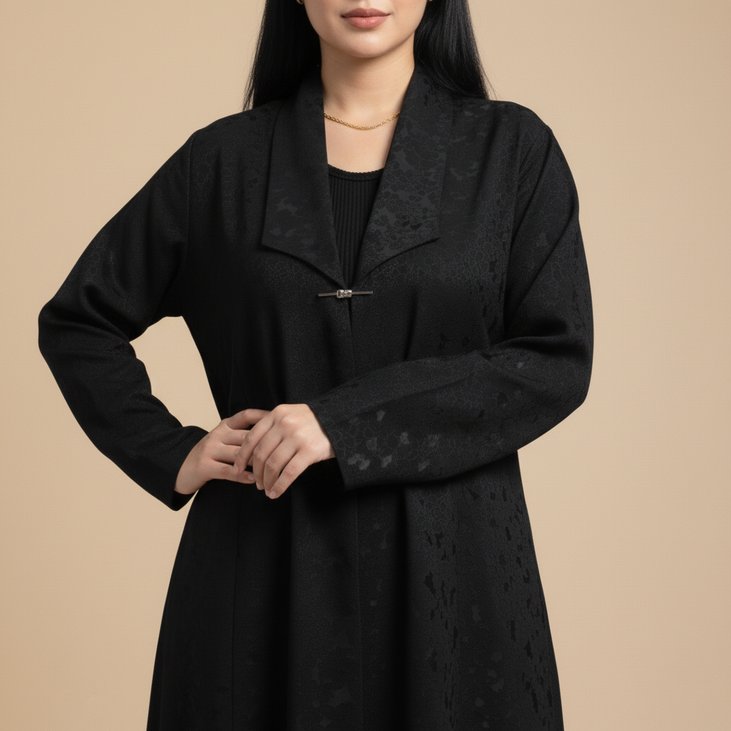 black jacquard abaya with a brooch.